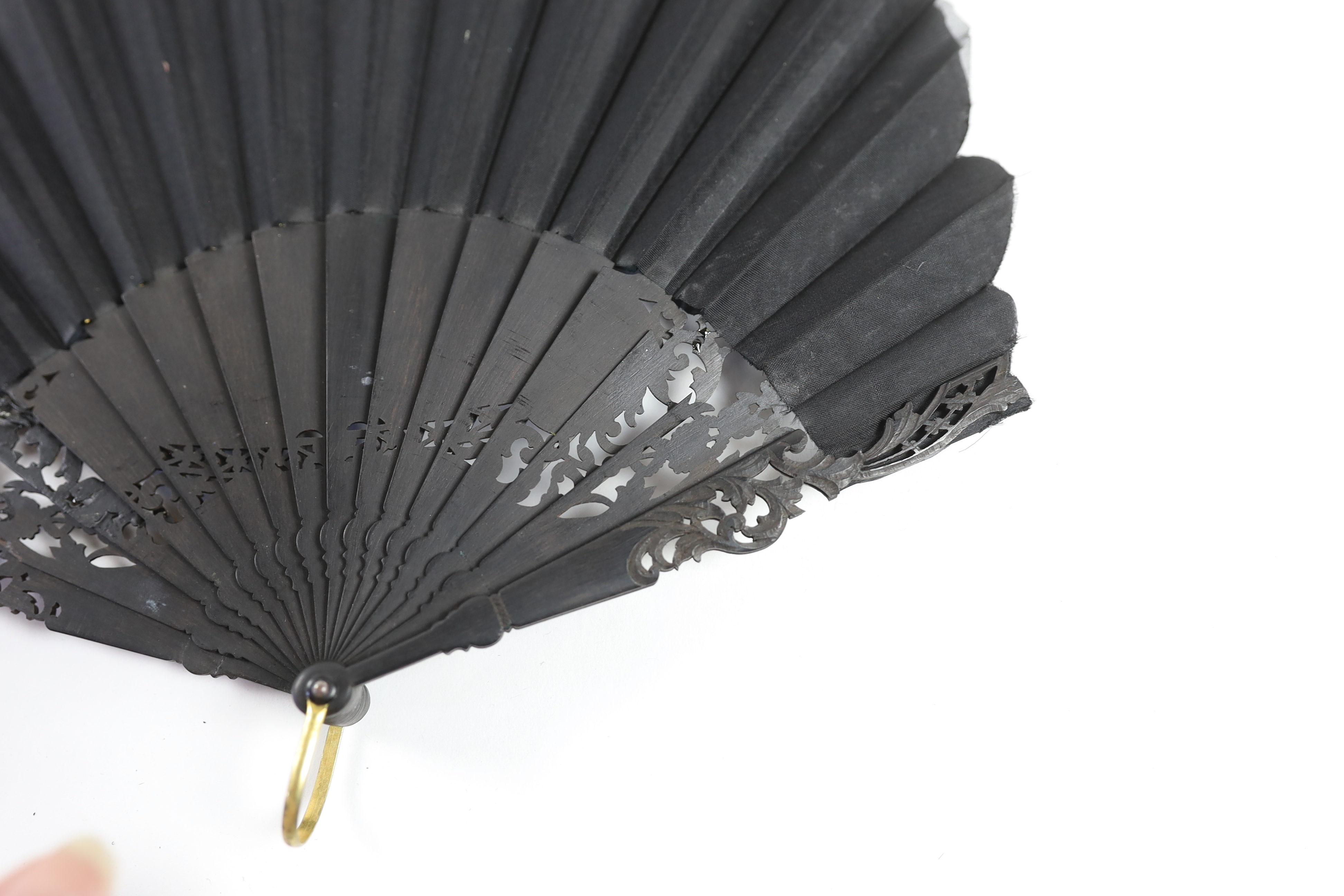 A late 19th century hand painted shaped and carved figurative fan, signed, together with a lacquer and mother of pearl fan, with matching leaf and guard decoration